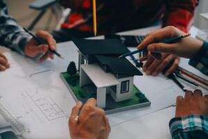 engineer people meeting working and pointing at a drawings in office for discussing. Engineering tools and construction concept. photo