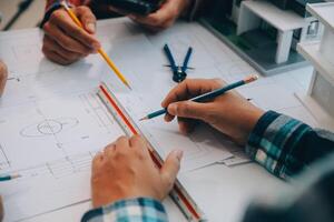 engineer people meeting working and pointing at a drawings in office for discussing. Engineering tools and construction concept. photo