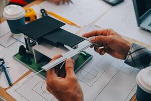 imagen de ingeniero reunión para arquitectónico proyecto. trabajando con compañero y Ingenieria herramientas en lugar de trabajo Clásico tono. foto