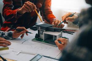 engineer people meeting working and pointing at a drawings in office for discussing. Engineering tools and construction concept. photo