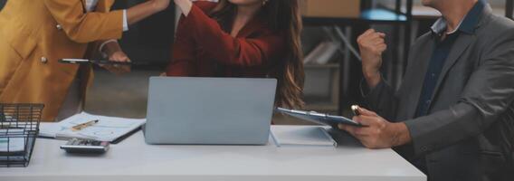 grupo de jóvenes empresarios asiáticos del equipo de negocios creativos compañeros de trabajo en el cargo felices de tener éxito en el trabajo en equipo de la asociación celebrando el logro y el concepto de éxito. foto