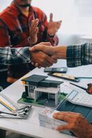 Architect and engineer construction workers shaking hands while working for teamwork and cooperation concept after finish an agreement in the office construction site, success collaboration concept photo