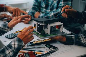 engineer people meeting working and pointing at a drawings in office for discussing. Engineering tools and construction concept. photo