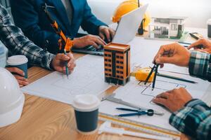 Image of engineer meeting for architectural project. working with partner and engineering tools on workplace vintage tone. photo