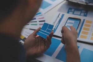 Close up ux developer and ui designer use augmented reality brainstorming about mobile app interface wireframe design on desk at modern office.Creative digital development agency photo