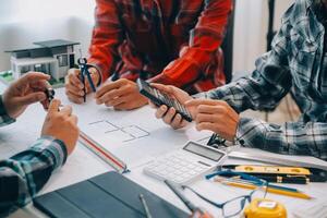 engineer people meeting working and pointing at a drawings in office for discussing. Engineering tools and construction concept. photo