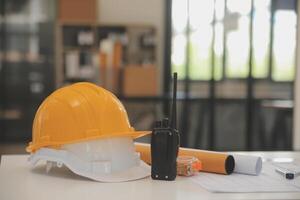 Male and Female Industrial Engineers in Hard Hats Discuss New Project while Using Laptop. They Make Showing Gestures.They Work in a Heavy Industry Manufacturing Factory. photo