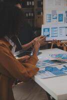 Close up ux developer and ui designer use augmented reality brainstorming about mobile app interface wireframe design on desk at modern office.Creative digital development agency photo