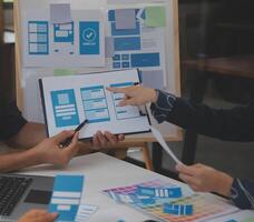 Close up ux developer and ui designer use augmented reality brainstorming about mobile app interface wireframe design on desk at modern office.Creative digital development agency photo