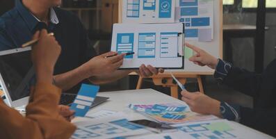 Close up ux developer and ui designer use augmented reality brainstorming about mobile app interface wireframe design on desk at modern office.Creative digital development agency photo