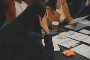 equipo de joven asiático empresario tener grave y desacuerdo en equipo reunión para próximo proyecto para márketing y rebaja administración con rascacielos ver para negocio puesta en marcha y educación concepto foto