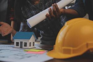 A team of construction engineers talks to managers and construction workers at the construction site. Quality inspection, work plan, home and industrial building design project photo