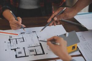 A team of construction engineers talks to managers and construction workers at the construction site. Quality inspection, work plan, home and industrial building design project photo