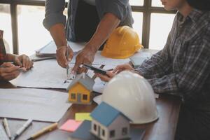 A team of construction engineers talks to managers and construction workers at the construction site. Quality inspection, work plan, home and industrial building design project photo