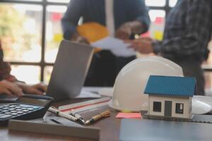 A team of construction engineers talks to managers and construction workers at the construction site. Quality inspection, work plan, home and industrial building design project photo