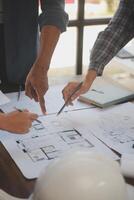 A team of construction engineers talks to managers and construction workers at the construction site. Quality inspection, work plan, home and industrial building design project photo