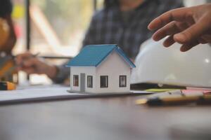 A team of construction engineers talks to managers and construction workers at the construction site. Quality inspection, work plan, home and industrial building design project photo