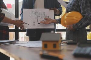 A team of construction engineers talks to managers and construction workers at the construction site. Quality inspection, work plan, home and industrial building design project photo