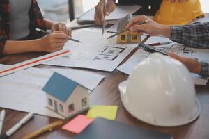 A team of construction engineers talks to managers and construction workers at the construction site. Quality inspection, work plan, home and industrial building design project photo