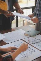 A team of construction engineers talks to managers and construction workers at the construction site. Quality inspection, work plan, home and industrial building design project photo