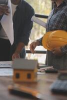 A team of construction engineers talks to managers and construction workers at the construction site. Quality inspection, work plan, home and industrial building design project photo