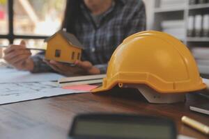 un equipo de construcción ingenieros negociaciones a gerentes y construcción trabajadores a el construcción sitio. calidad inspección, trabajo plan, hogar y industrial edificio diseño proyecto foto