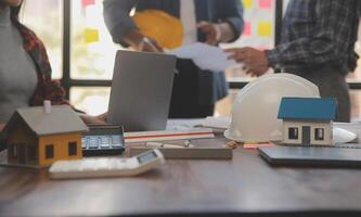 A team of construction engineers talks to managers and construction workers at the construction site. Quality inspection, work plan, home and industrial building design project photo