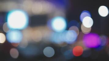 Beautiful bokeh in a dark blurry background at night on the walking street with the people. The round colorful bokeh shine from buildings and shops in the city lifestyle. Abstract concept. video