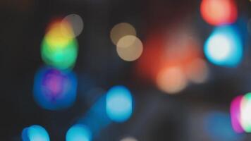 Beautiful bokeh in a dark blurry background at night on the walking street with the people. The round colorful bokeh shine from buildings and shops in the city lifestyle. Abstract concept. video