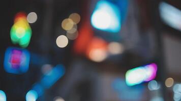 Beautiful bokeh in a dark blurry background at night on the walking street with the people. The round colorful bokeh shine from buildings and shops in the city lifestyle. Abstract concept. video