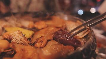 dichtbij omhoog schot van hand- Koken Koreaans gegrild varkensvlees buik vlees en gebruik schaar naar besnoeiing vlees Aan ijzer rooster pan.varkensvlees buik Aan een grill, samgyupsal, koken varkensvlees buik Aan een pan, koreaans varkensvlees barbecue video