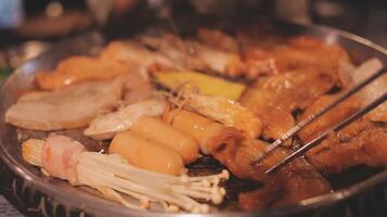 schließen oben Schuss von Hand Kochen Koreanisch gegrillt Schweinefleisch Bauch Fleisch und verwenden Schere zu Schnitt Fleisch auf Eisen Grill pan.schweinefleisch Bauch auf ein Grill, Samgyupsal, Kochen Schweinefleisch Bauch auf ein Pfanne, koreanisch Schweinefleisch Grill video