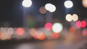 Beautiful bokeh in a dark blurry background at night on the walking street with the people. The round colorful bokeh shine from buildings and shops in the city lifestyle. Abstract concept. video