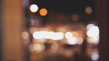 Beautiful bokeh in a dark blurry background at night on the walking street with the people. The round colorful bokeh shine from buildings and shops in the city lifestyle. Abstract concept. video