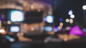 schön Bokeh im ein dunkel verschwommen Hintergrund beim Nacht auf das Gehen Straße mit das Personen. das runden bunt Bokeh scheinen von Gebäude und Geschäfte im das Stadt Lebensstil. abstrakt Konzept. video