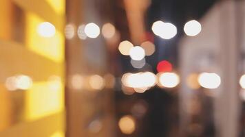 Beautiful bokeh in a dark blurry background at night on the walking street with the people. The round colorful bokeh shine from buildings and shops in the city lifestyle. Abstract concept. video