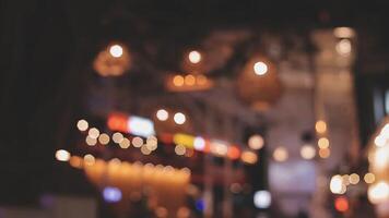 schön Bokeh im ein dunkel verschwommen Hintergrund beim Nacht auf das Gehen Straße mit das Personen. das runden bunt Bokeh scheinen von Gebäude und Geschäfte im das Stadt Lebensstil. abstrakt Konzept. video