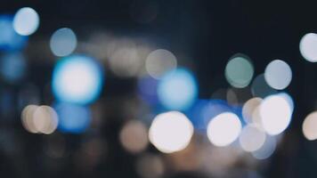 Beautiful bokeh in a dark blurry background at night on the walking street with the people. The round colorful bokeh shine from buildings and shops in the city lifestyle. Abstract concept. video