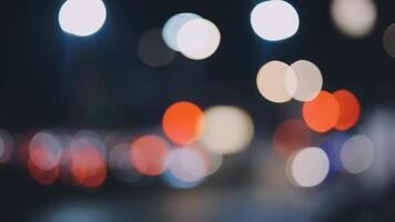 Beautiful bokeh in a dark blurry background at night on the walking street with the people. The round colorful bokeh shine from buildings and shops in the city lifestyle. Abstract concept. video