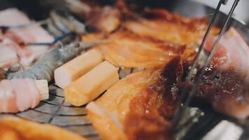 Close up shot of hand cooking Korean grilled pork belly meat and use scissors to cut meat on iron grill pan.pork belly on a grill,samgyupsal,Cooking pork belly on a pan,korean pork barbecue video