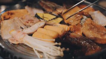 schließen oben Schuss von Hand Kochen Koreanisch gegrillt Schweinefleisch Bauch Fleisch und verwenden Schere zu Schnitt Fleisch auf Eisen Grill pan.schweinefleisch Bauch auf ein Grill, Samgyupsal, Kochen Schweinefleisch Bauch auf ein Pfanne, koreanisch Schweinefleisch Grill video