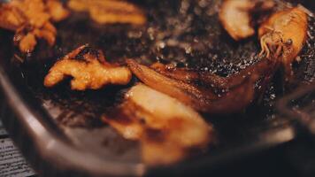 fechar acima tiro do mão cozinhando coreano grelhado carne de porco barriga carne e usar tesouras para cortar carne em ferro grade panela.porco barriga em uma grelhar, samgyupsal, cozinhar carne de porco barriga em uma panela, coreano carne de porco churrasco video