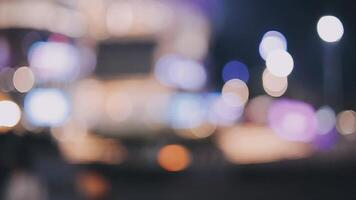 schön Bokeh im ein dunkel verschwommen Hintergrund beim Nacht auf das Gehen Straße mit das Personen. das runden bunt Bokeh scheinen von Gebäude und Geschäfte im das Stadt Lebensstil. abstrakt Konzept. video