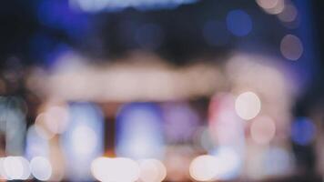 Beautiful bokeh in a dark blurry background at night on the walking street with the people. The round colorful bokeh shine from buildings and shops in the city lifestyle. Abstract concept. video