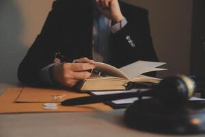 Business and lawyers discussing contract papers with brass scale on desk in office. Law, legal services, advice, justice and law concept picture with film grain effect photo