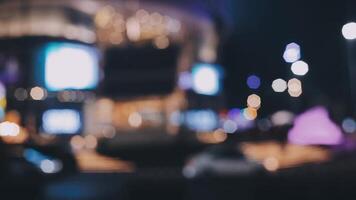 Beautiful bokeh in a dark blurry background at night on the walking street with the people. The round colorful bokeh shine from buildings and shops in the city lifestyle. Abstract concept. video