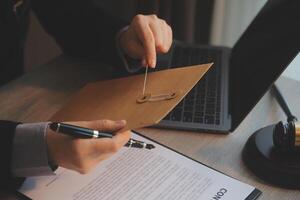 Business and lawyers discussing contract papers with brass scale on desk in office. Law, legal services, advice, justice and law concept picture with film grain effect photo