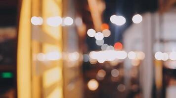 Beautiful bokeh in a dark blurry background at night on the walking street with the people. The round colorful bokeh shine from buildings and shops in the city lifestyle. Abstract concept. video