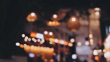 Beautiful bokeh in a dark blurry background at night on the walking street with the people. The round colorful bokeh shine from buildings and shops in the city lifestyle. Abstract concept. video