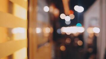 Beautiful bokeh in a dark blurry background at night on the walking street with the people. The round colorful bokeh shine from buildings and shops in the city lifestyle. Abstract concept. video